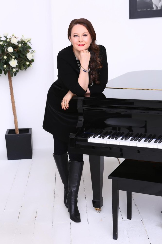 Olga Thomas at the piano, white studio