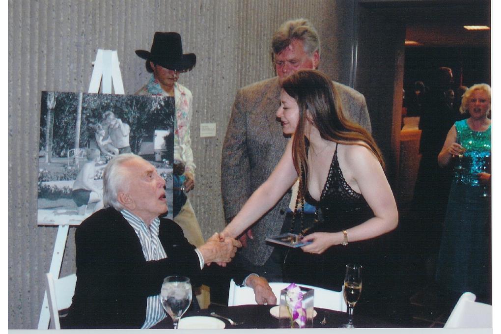 Olga Thomas shaking hands with Kirk Douglas